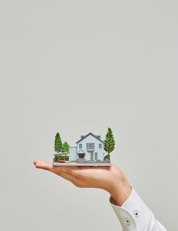 Casa em miniatura apoiada por uma mão